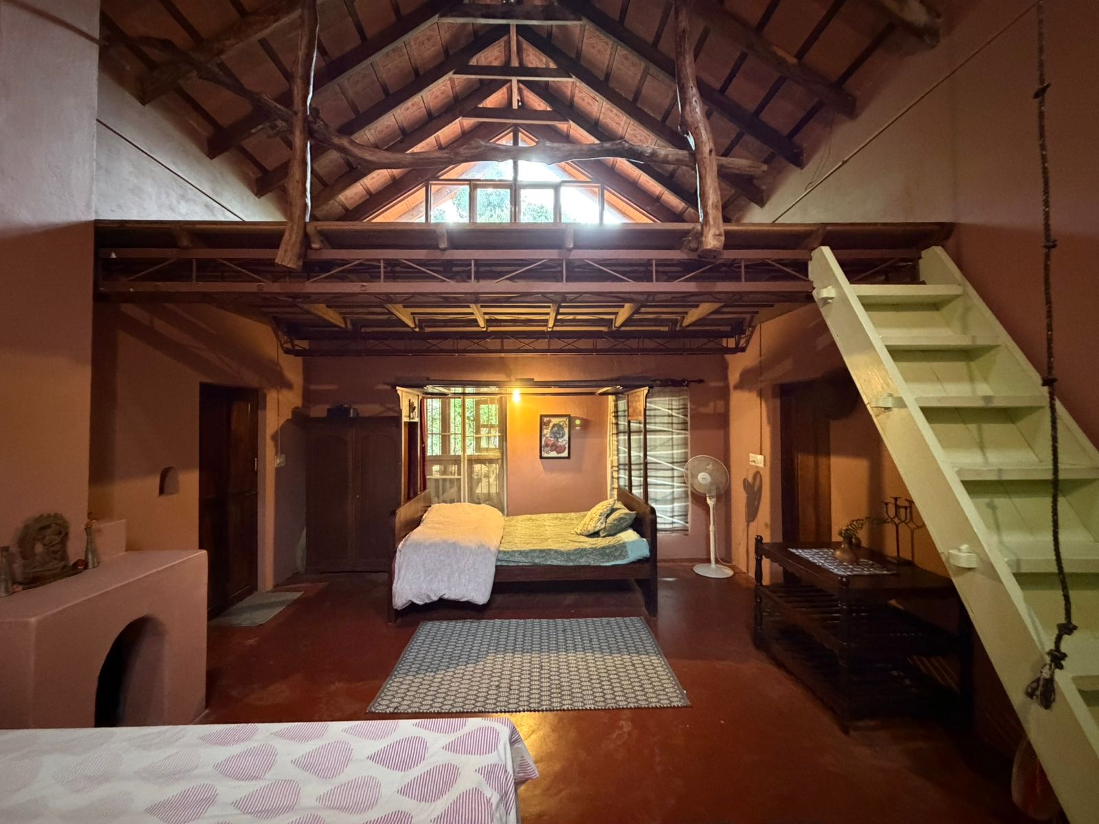 High-ceilinged interior with wooden beams and loft
