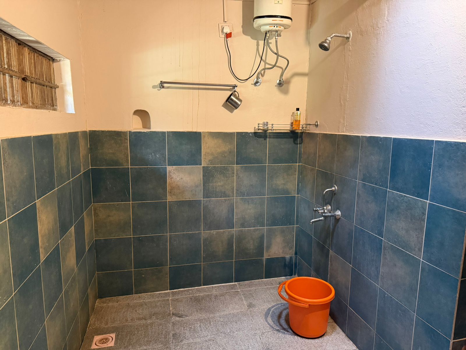 Shower area with geyser and blue tiles
