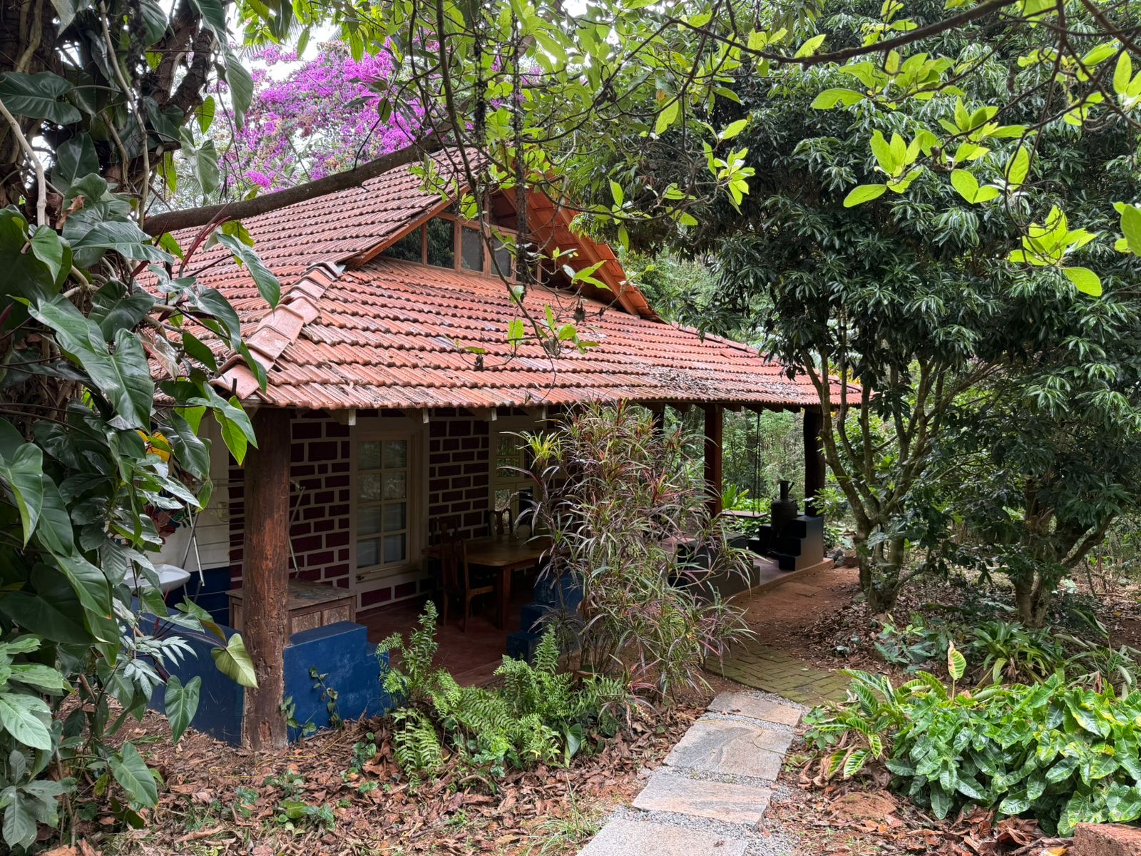 Brick and tile cottage tucked among trees and bougainvillea